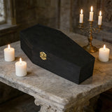 Matte black wooden pet memorial urn displayed beside candles